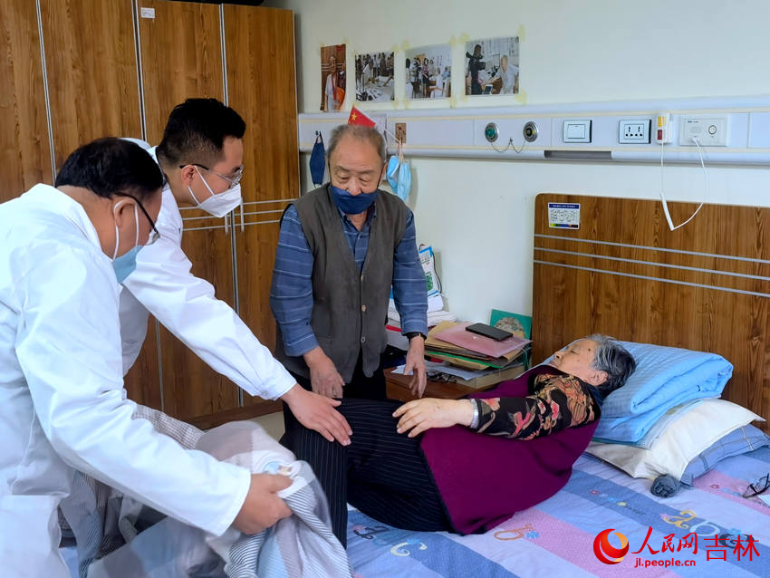 醫生查房幫助老人挪動身體。人民網 馬俊華攝