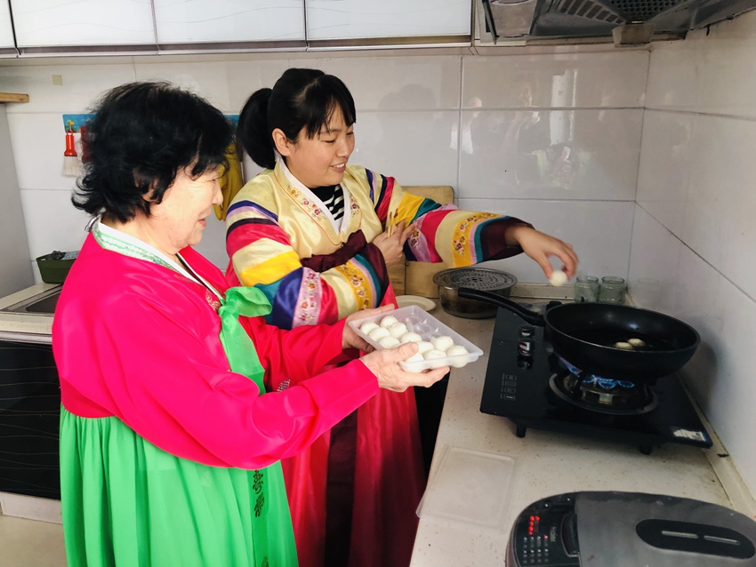 社區工作人員與老人一起炸元宵