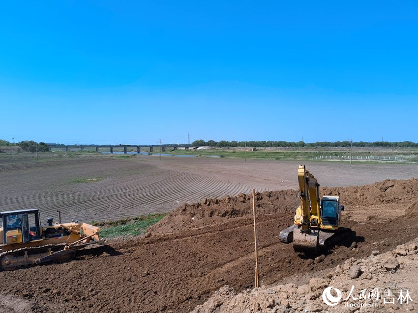 兩臺工程車“加培”堤防忙不停。人民網記者 馬俊華攝