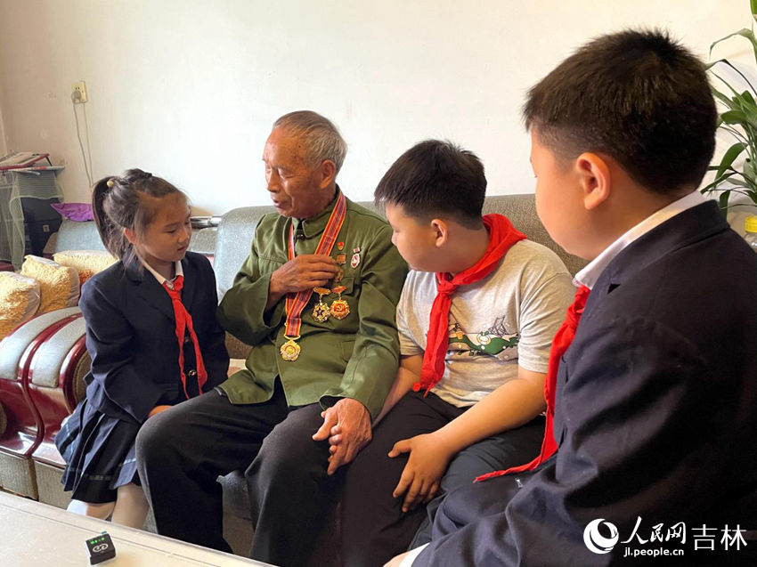向德明同少先隊員們講述勛章背后的故事。人民網記者 李思玥攝