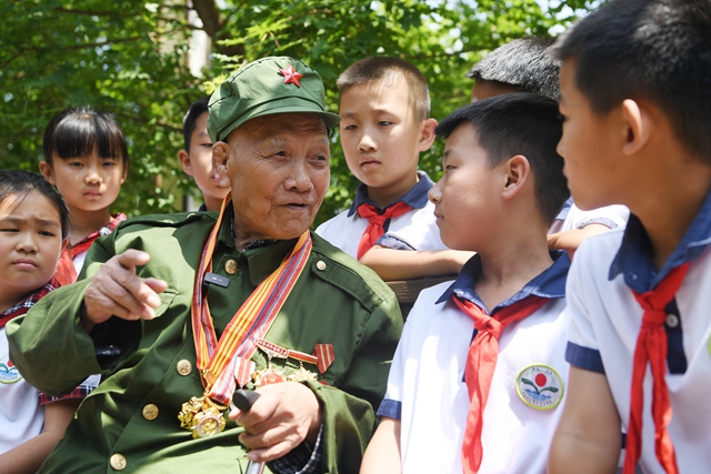 老兵楊建為孩子們講述自己在戰場上的經歷。