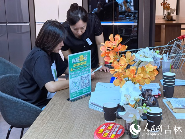 商場銷售人員指導消費者使用以舊換新小程序。人民網記者 馬俊華攝