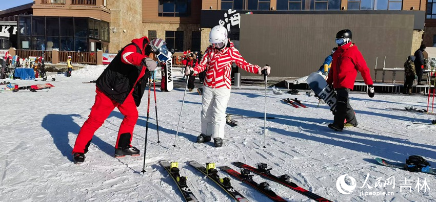 北大湖滑雪度假區單雙板高級滑雪教練王玉喜（左）正耐心地示范教學。人民網記者 王海躍攝