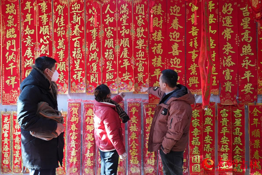 大集上，趙百強（左）與妻子在挑選春聯。人民網記者 李洋攝
