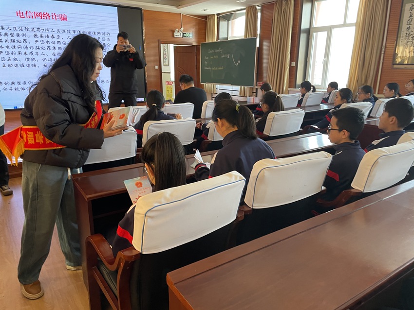 鐵東區司法局工作人員為學生們發送《民法典》法律知識書籍。