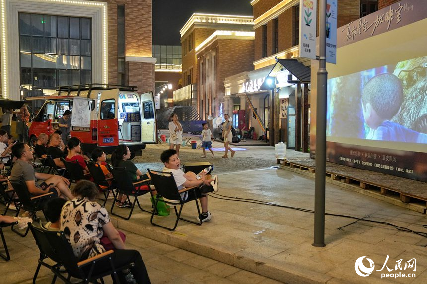 游客在春京西文旅街區觀看露天電影。人民網記者 李洋攝