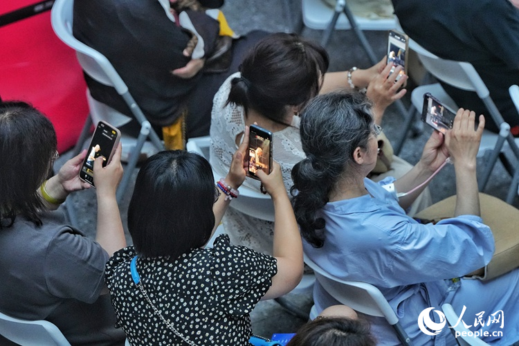 觀眾們紛紛舉起手機記錄下這難忘的瞬間。人民網記者 李洋攝
