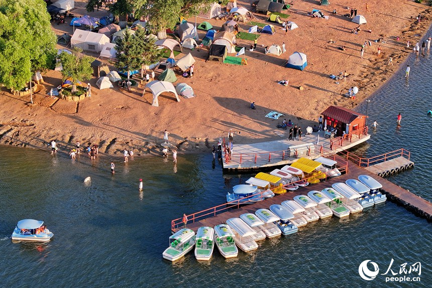 清爽夏日，游客在長春南湖金沙灘戲水游玩盡享清涼。人民網記者 李洋攝 