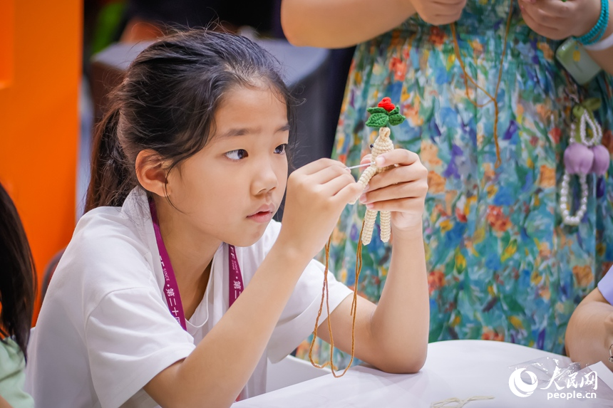 一名小朋友在“吉林巧姐”展區動手創作。人民網記者 李洋攝