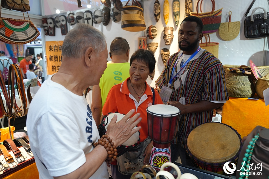 游客在第十五屆中國—東北亞博覽會上試用金貝鼓。人民網記者 李洋攝