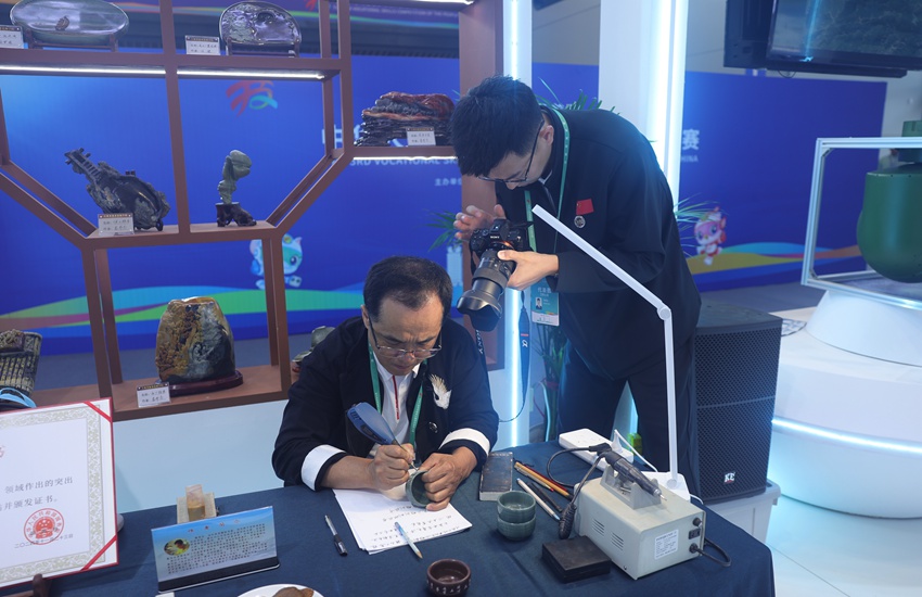 吉林省工藝美術大師、省級非遺傳承人竇茂忠認真雕刻著手中的松花石。不一會兒工夫，一個個精美的字組成極具韻味的詞句，躍然“石”上。楊宜修攝