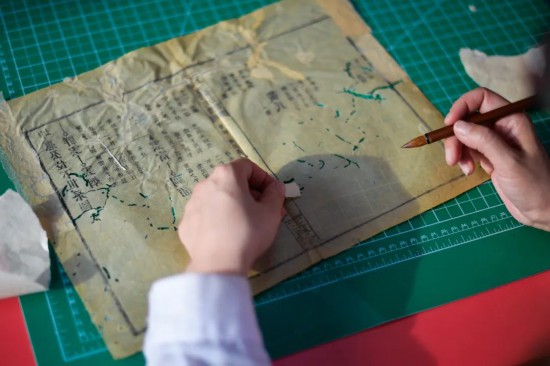 “全國古籍重點保護單位”吉林大學圖書館內館藏古籍近40萬冊，其中善本書6000余部。學校自20世紀50年代便開始進行古籍整理修復工作，數十年間從未間斷。圖為4月19日，古籍修復師為古籍書頁配紙“補洞”。許暢攝